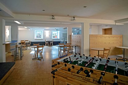 Blick in den Partykeller mit Kicker und Sitzgruppen