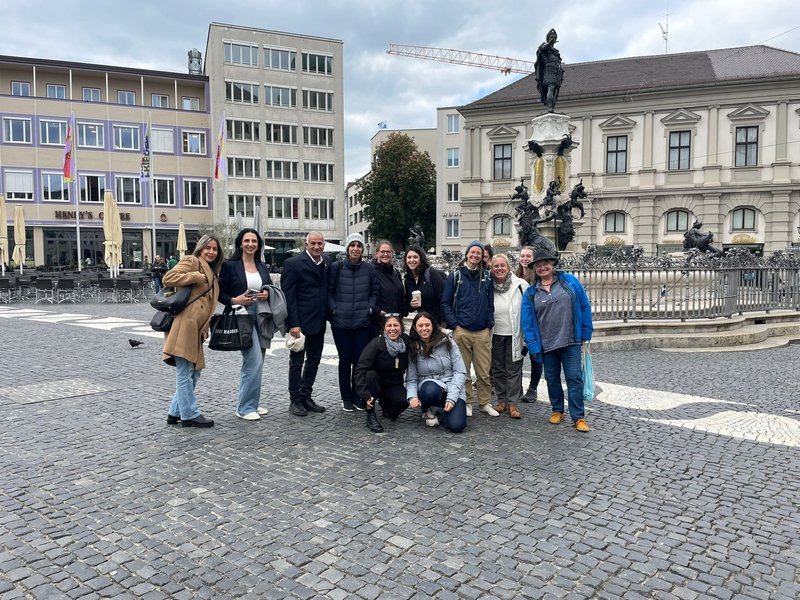 Gruppenbild von ca. 12 Personen vor dem Augusta Brunnen in Augsburg