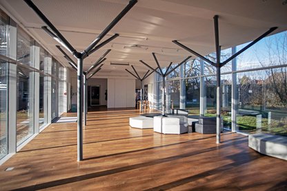 Blick in den lichtdurchfluteten Glasdurchgang mit Sitzgruppe